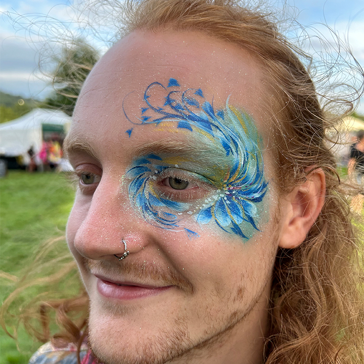 Festival face painting at Green Man festival - Blue and green foliate design